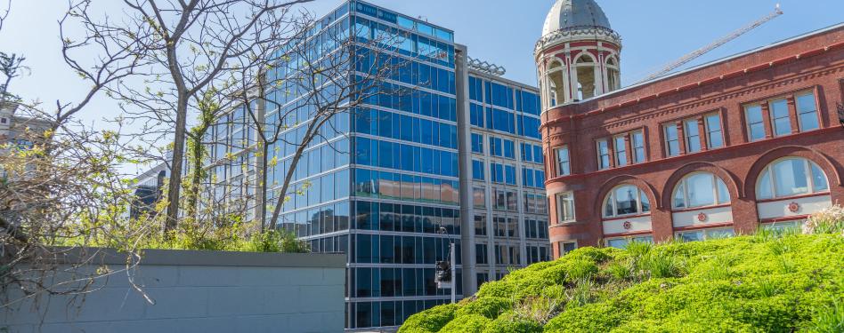 A modern office building next to a historic brick building.